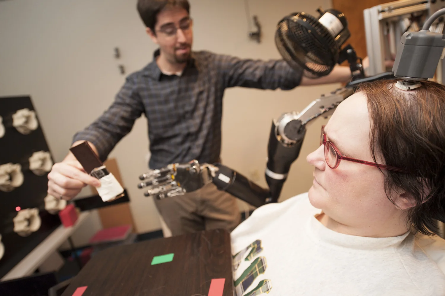 Woman using an assistive robotic arm in a laboratory