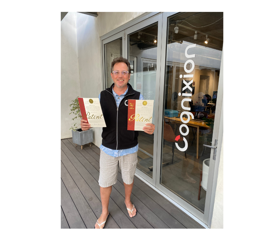 Person holding a Cognixion patent certificate outside the company office